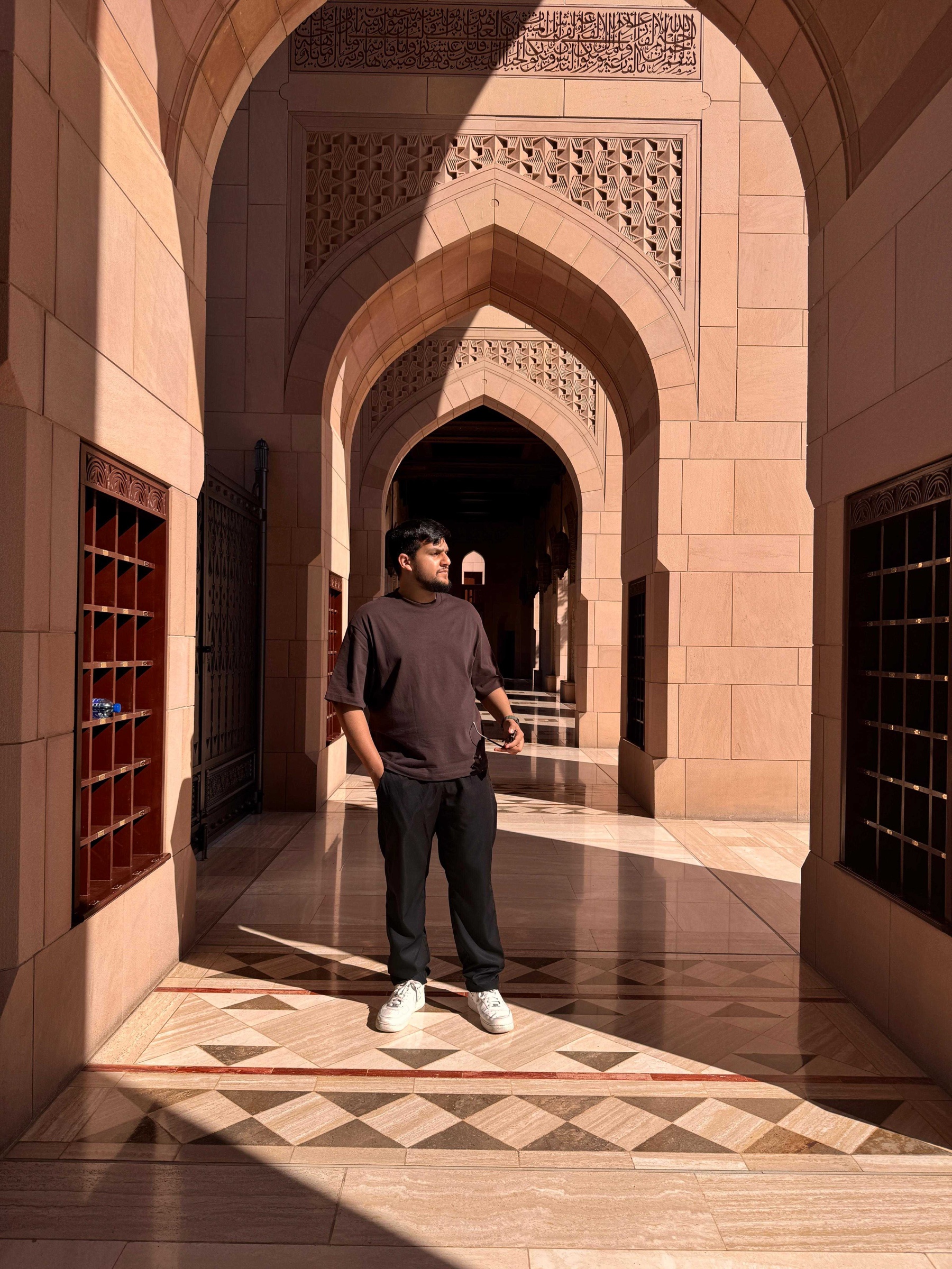 Mohammed Ubaidah standing beneath a series of sunlit stone arches